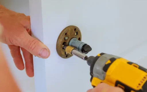 carpenter-at-lock-installation-with-electric-drill-2025-03-27-05-49-52-utc.webp